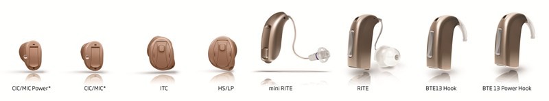 Eight hearing aids of varying sizes on white background